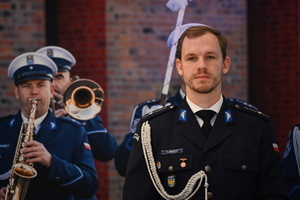 Zdjęcie przedstawia stojącego w mundurze galowym policjanta