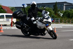 Policjant na motocyklu wykonuje manewr skrętu w prawo.
