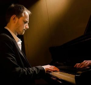 Tomasz Lis w trakcie gry na pianinie